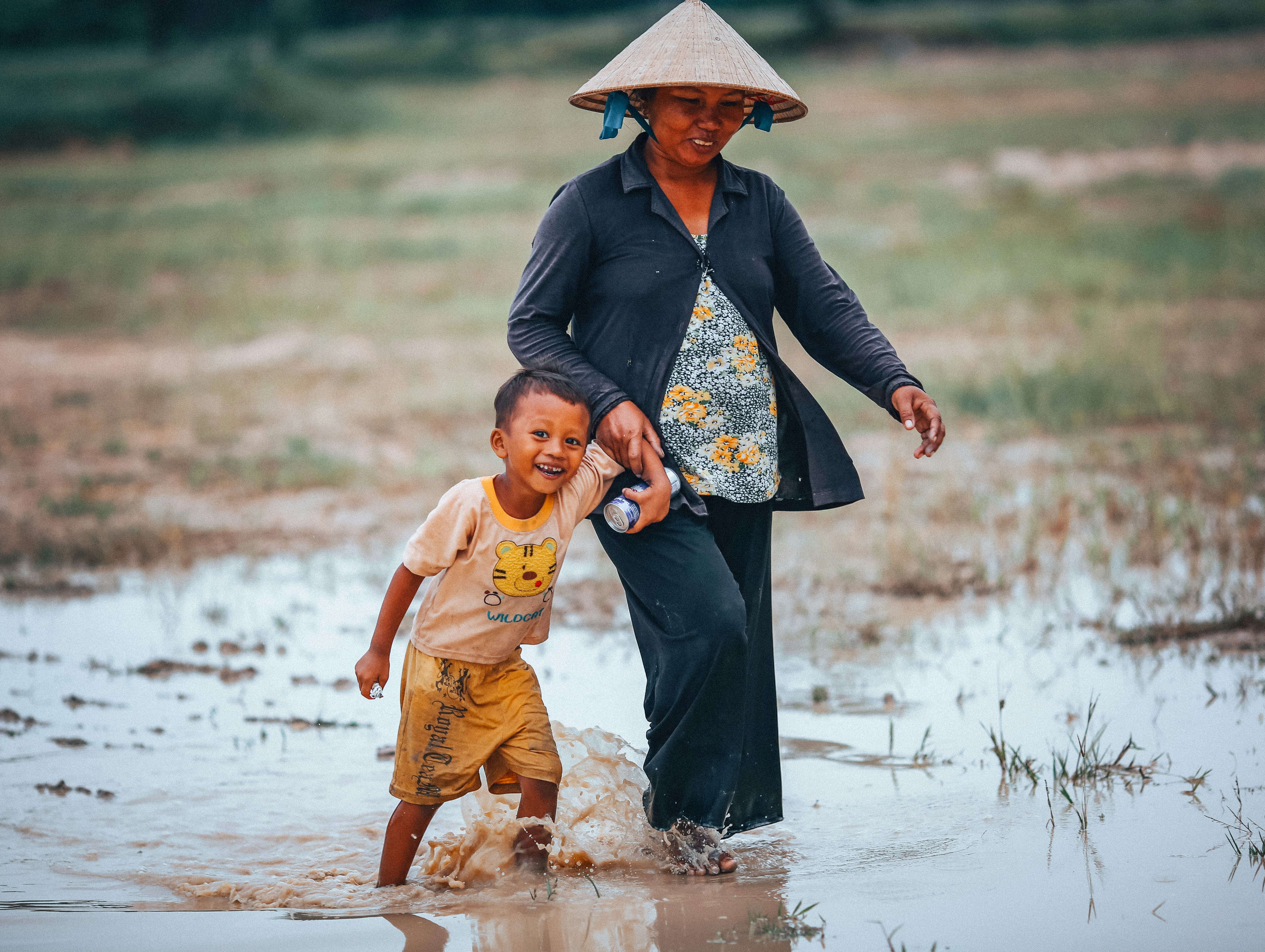 woman and boy walking on rice paddy